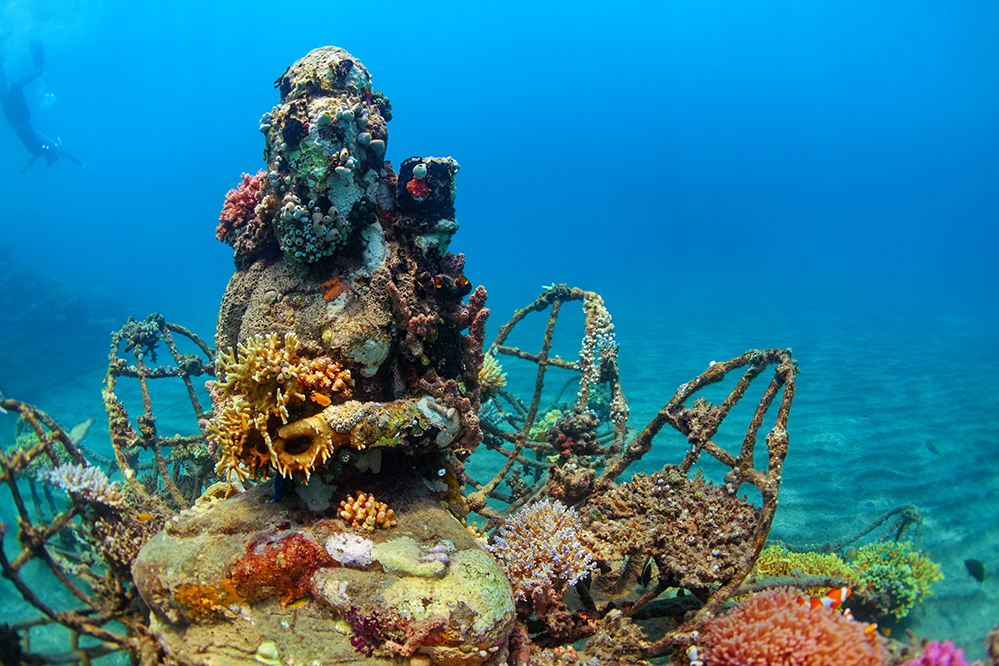 A coral covered Buddha statue rests at the bottom of the sea off the coast of Pemuteran, Indonesia (Photo by Tropical studio / Shutterstock)